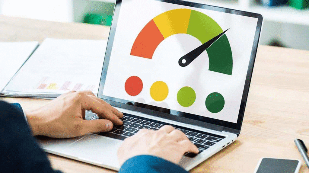 Hands typing on a laptop showing a speed gauge graphic with red, yellow, and green sections on the screen